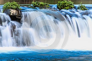 Waterfall in the blue river photo