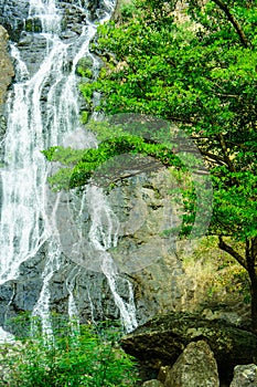 Waterfall around stones and forest