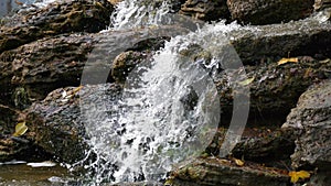 Waterfall in autumn. Water flows over the stones.