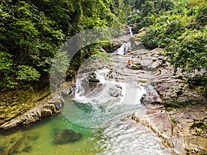 Waterfall with big rock bank in the green tropical forest