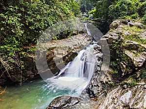 Waterfall with big rock bank in the tropical forest