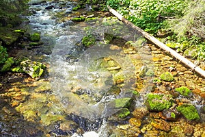 Waterfall in blurring with a flowing waters, stones are around the waters