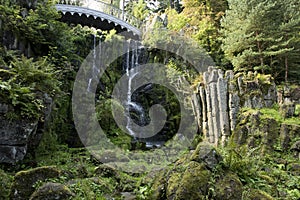 Waterfall and bridge in Park of Castle Wilhelmshoehe, Kassel, Germany. Scenic landscape