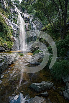 Waterfall caresses the granite rock before falling into a pool and forming a stream photo