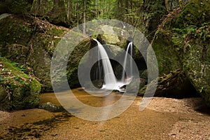 Waterfall, cascade between big rocks in ravine Ysperklamm