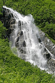 Waterfall Cascading from Mountain peak spring snowmelt southeast Alaska valdez