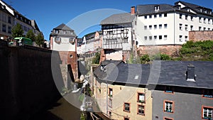 Waterfall in the city center of Saarburg, Germany surrounded by houses on a hill. Zoom out effect