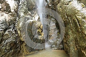 Waterfall close up. Water cascade on moss stones