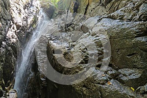 Waterfall close up. Water cascade on moss stones