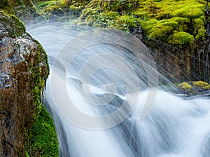 Waterfall close-up, water splashes, wildlife concept. Atmospheric minimal landscape with a long exposure of a large waterfall on a