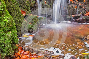 Waterfall in creek in Turovska roklina gorge during autumn in Kremnicke vrchy mountains