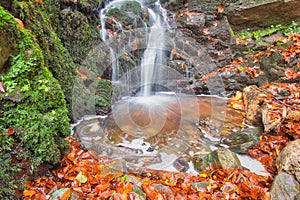 Waterfall in creek in Turovska roklina gorge during autumn in Kremnicke vrchy mountains