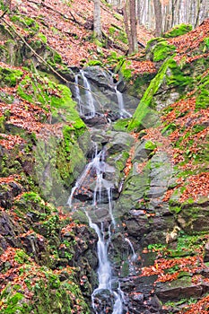 Waterfall in creek in Turovska roklina gorge during autumn in Kremnicke vrchy mountains