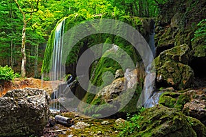 Waterfall in Crimea forest and wet mossy stone