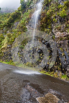 Waterfall falling to road above Encumeada mountain pass in Madeira
