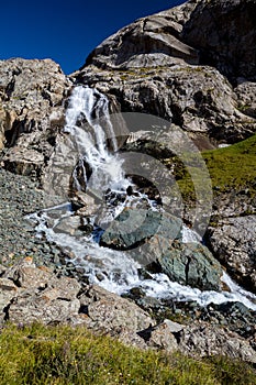 Waterfall flowing from Ala-Kul lake. Kyrgyzstan