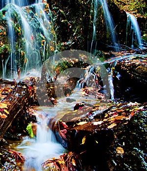 Waterfall Flowing Around Large Boulders in Autumn