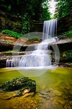 waterfall flowing over a rocky cliff into a small pool of water