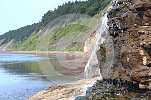 The waterfall flows down to the sea. Sakhalin