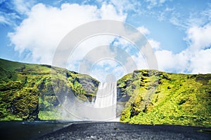 Waterfall between green cliffs