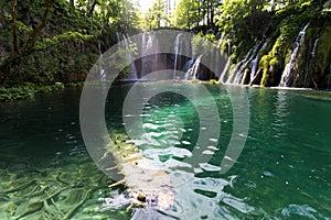 Waterfall and Green Lake in Autumn in Plitvice Lakes National Park