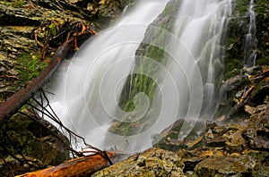 Waterfall among green wet stones