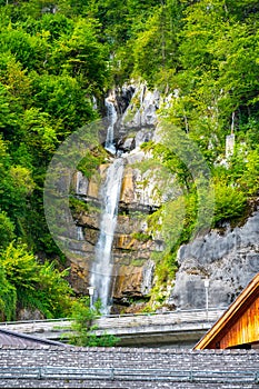 Waterfall at Hallstat city, Austria. Fresh water stream above city roofs