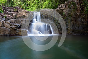 The waterfall in the hill behind a pond in jungle