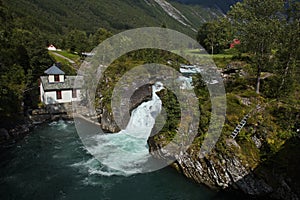 Waterfall and Hoelsfossen hydroelectric power station on the river Valldola, More og Romsdal county, Norway