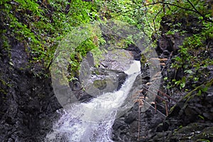 Waterfall Jaco Costa Rica, Catarastas Valle Encantado - Hidden waterfall surrounded by green trees, vegetation, rocks, leaves floa photo