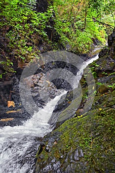 Waterfall Jaco Costa Rica, Catarastas Valle Encantado - Hidden waterfall surrounded by green trees, vegetation, rocks, leaves floa photo