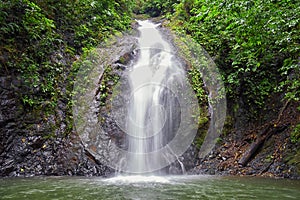 Waterfall Jaco Costa Rica, Catarastas Valle Encantado - Hidden waterfall surrounded by green trees, vegetation, rocks, leaves floa photo