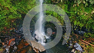 Waterfall jet flowing mossy cliffs aerial view. Streaming water crashing rocks