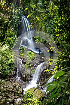 Waterfall landscape. Beautiful hidden Pengibul waterfall in rainforest. Tropical scenery. Slow shutter speed, motion photography.