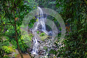 Waterfall landscape. Beautiful hidden Pengibul waterfall in rainforest. Tropical scenery. Slow shutter speed, motion photography.