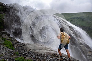 Waterfall Landscape and male Traveler enjoying waterfall view