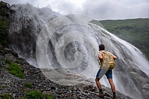 Waterfall Landscape and male Traveler enjoying waterfall view