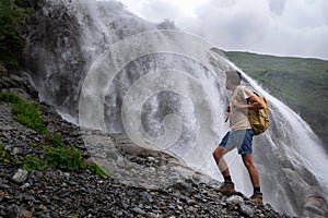 Waterfall Landscape and male Traveler enjoying waterfall view