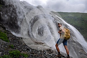 Waterfall Landscape and male Traveler enjoying waterfall view