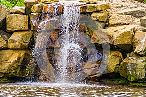 Waterfall with large boulders, Beautiful garden architecture, nature background of streaming water