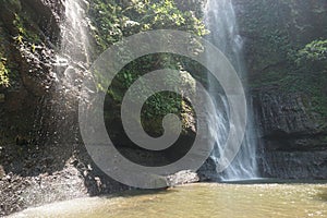 A waterfall located in the middle of a forest in the mountains of Cimahi City