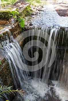 Small artificial waterfall, made at the source in Parque das ÃÂguas. photo
