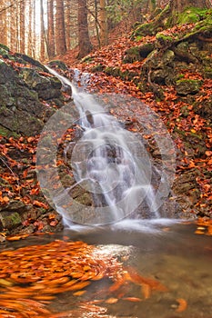 Waterfall in mountain creek in Tajovska dolina gorge near Tajov village during autumn