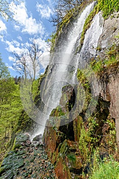Waterfall in a mountain forest in early spring