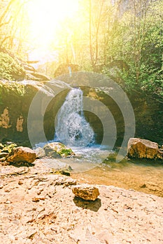 Waterfall on a mountain river in the forest on a balmy spring day