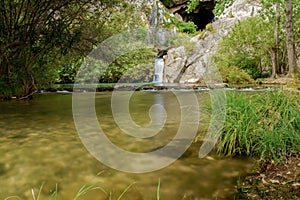 Waterfall of a mountain river with lush vegetation