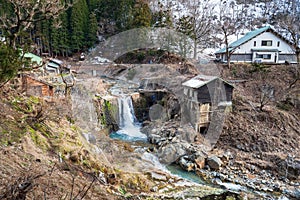 waterfall on mountain and small ryokan at Jigokudani Monkey Park