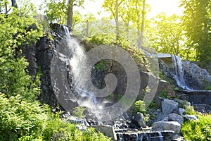 Waterfall in a public place on the Russian island under the rays of a bright sun