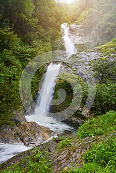 Waterfall in rain forest with flare of sun light at Mae Pan waterfall,Chiangmai, Thailand