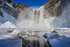 waterfall with rainbow and ice